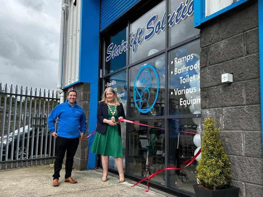 Karen Douglas, the Mayor of Ards and North Downs, cuts the ribbon to officially open the new showroom, watched by Michael Wallace
